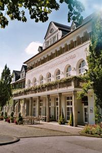 ein großes weißes Gebäude mit vielen Fenstern in der Unterkunft Mintrops Stadt Hotel Margarethenhöhe in Essen