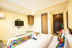 a hotel room with a bed and a tv at FabExpress Silver Lake - Nr BKC in Mumbai +22 photos