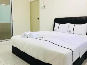 a large bed with white sheets and towels on it at SLV Small Luxury Villa - Villa B in Malacca
