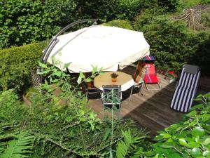 a gazebo with a table and chairs on a wooden deck at Ferienhaus Luhetalblick Prescher in Bispingen +3 photos