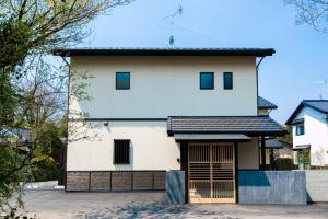 Biały dom z garażem w obiekcie Kotonone Mai Suzu w mieście Yufu