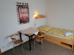 um pequeno quarto com uma cama, uma mesa e cadeiras em Ferienhaus Luhetalblick Prescher em Bispingen