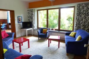 ein Wohnzimmer mit 2 blauen Sofas und einem TV in der Unterkunft O11- Großzügige Fewo im Künstlerhaus in Lichtenfels-Sachsenberg
