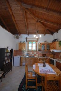 a kitchen with wooden cabinets and a wooden table with chairs at Villa Frias in Asprogerakata