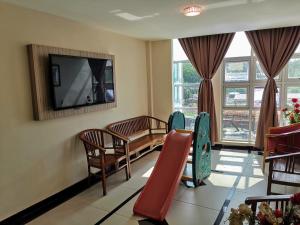 ein Wartezimmer mit einem Tisch und Stühlen sowie einem Flachbild-TV in der Unterkunft Hotel Centre Point Tampin in Malakka