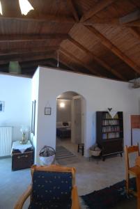 a living room with wooden ceilings and a room with a couch at Villa Frias in Asprogerakata