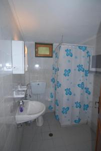 a bathroom with a sink and a toilet and a shower at Villa Frias in Asprogerakata