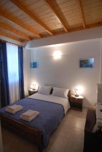 a bedroom with a bed with two towels on it at Villa Frias in Asprogerakata