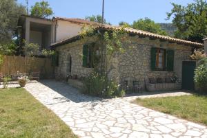 a stone house with a patio in front of it at Villa Frias in Asprogerakata