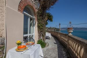 a table on a balcony with a view of the water at La Mia Casa in Portovenere