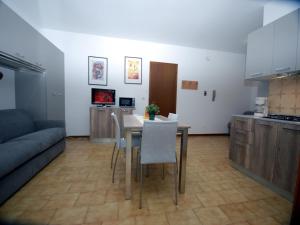 cocina y comedor con mesa y sillas en Appartamenti Dei Fiori, en Lignano Sabbiadoro