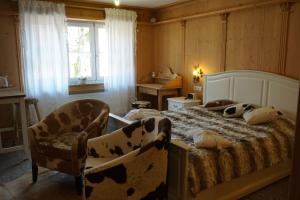 テットナングにあるLandhotel Gutshof Camping Badhüttenのベッドルーム1室(ベッド1台、椅子2脚、窓付)