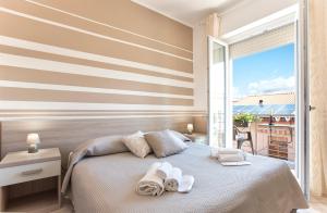 een slaapkamer met een bed met handdoeken erop bij Alguest in Alghero