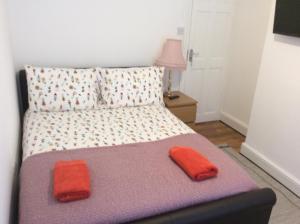 a bedroom with a bed with two red pillows on it at 96 Rochester Street in Chatham