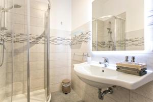 a white bathroom with a sink and a shower at Alguest in Alghero