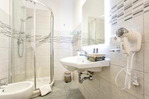 a white bathroom with a sink and a shower at Alguest in Alghero