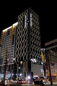 eine große Skulptur eines Gebäudes in einer Stadt nachts in der Unterkunft Astro Hotel in Yongin