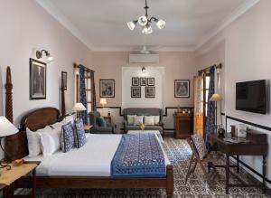 - une chambre avec un grand lit et un canapé dans l'établissement Ratan Vilas, à Jodhpur