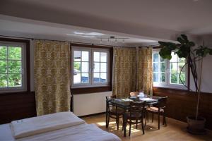 a bedroom with a table and a bed and windows at Gutshof-Hotel Waldknechtshof in Baiersbronn