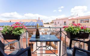 Una botella de vino en una mesa en un balcón en Alguest, en Alghero