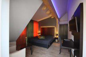 a bedroom with a bed and a tv in a room at Hotel Restaurant Lindenhof in Bad Laasphe