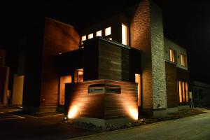 a building with lights on the side of it at night at Shiretokoserai in Rausu