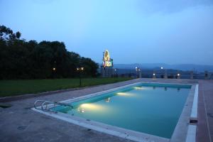 una piscina notturna con un orologio sullo sfondo di Goha Hotel a Gonder