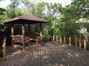 a wooden deck with a gazebo and a bench at The House 15 Villa in Hengchun