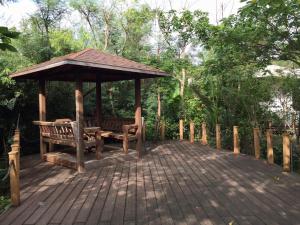 a wooden deck with a gazebo and a bench at The House 15 Villa in Hengchun South Gate