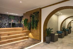 a lobby with a wooden staircase and plants at Hotel Rozmarin in Predeal