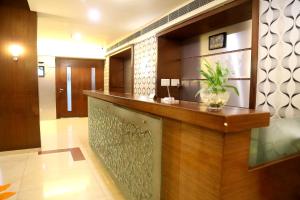 a lobby with a counter with a plant on it at Venkat Presidency in Navi Mumbai