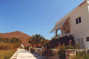 a white building with a fence next to a mountain at Angela's in Galissas
