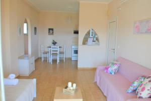sala de estar con sofá rosa y mesa en Lefkothea Apartments en Kassiopi