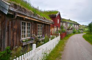 a dirt road next to a house with a white fence at Saga Trollheimen Hotel in Rindal