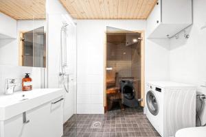 a bathroom with a washer and dryer in a room at Hämeentie Apartments in Järvenpää