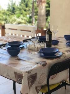 uma mesa de madeira com pratos azuis e uma garrafa de vinho em Aurora Home em Alcamo Marina