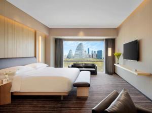 a hotel room with a bed and a view of the city at Hyatt Regency Beijing Wangjing in Beijing