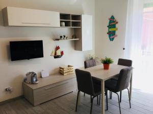 a dining room with a table and chairs and a television at Elite19 Apartment in Bocca di Magra