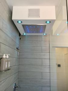 a bathroom with a shower with blue lights at Elite19 Apartment in Bocca di Magra +24 photos