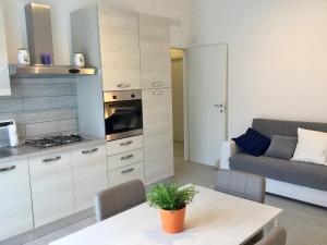 a kitchen and living room with a table and a couch at Elite19 Apartment in Bocca di Magra