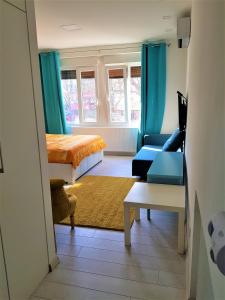 ein Wohnzimmer mit einem Bett und einem Sofa in der Unterkunft Asya Blue Studio in Belgrad