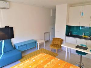 ein Wohnzimmer mit einem blauen Sofa und einer Küche in der Unterkunft Asya Blue Studio in Belgrad