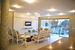 uma sala de espera com cadeiras, uma mesa e uma televisão em Hotel Oma Zita em Forquilhinha