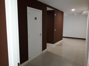 a hallway with a white door and brown walls at ALBERGUE CASTELOS VILALBA in Villalba