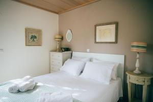 Schlafzimmer mit einem Bett mit weißer Bettwäsche und Kissen in der Unterkunft La Casa Rossa in Agios Nikitas