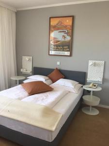 a bedroom with a large bed with two tables at Dietrichsteinerhof Apartments & Rooms in Faak am See