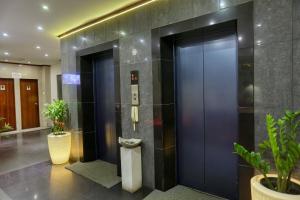 a lobby with two elevators in a building with plants at Colombo City Hotels (Pvt) Ltd in Colombo