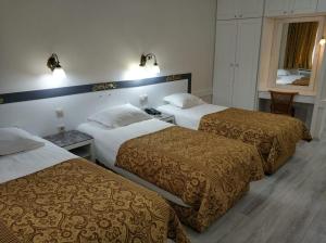 a hotel room with three beds and a window at Hali Hotel in Istanbul