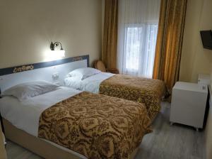 a hotel room with two beds and a window at Hali Hotel in Istanbul