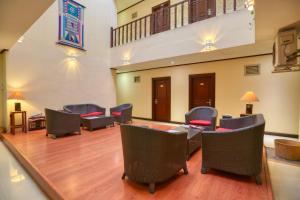 Colombo City Hotels (Pvt) Ltd في كولومبو: غرفة بها كراسي وطاولة ودرج